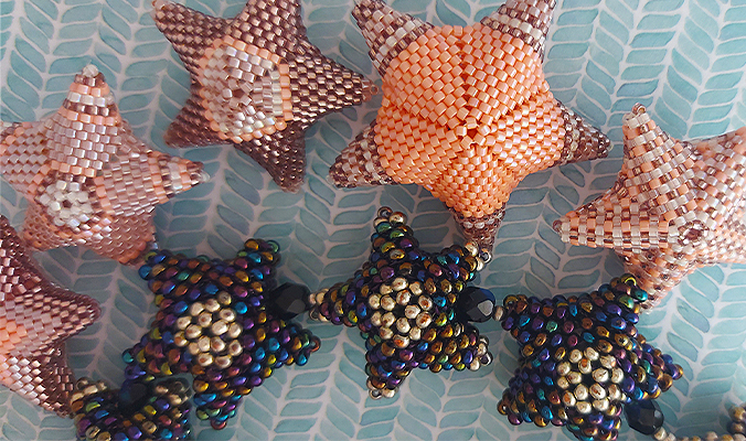 5 small pink and orange Peyote-stitched stars and four smaller blue and gold Peyote-stitched stars using different kinds of Miyuki beads