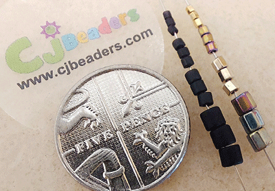 A five pence piece with various Miyuki bead sizes on a needle to the right